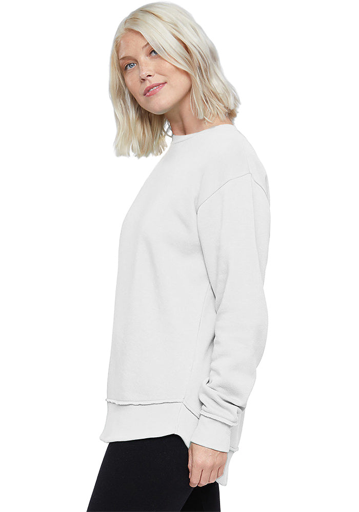 Side view of a woman wearing a white relaxed-fit cotton sweatshirt on a white background