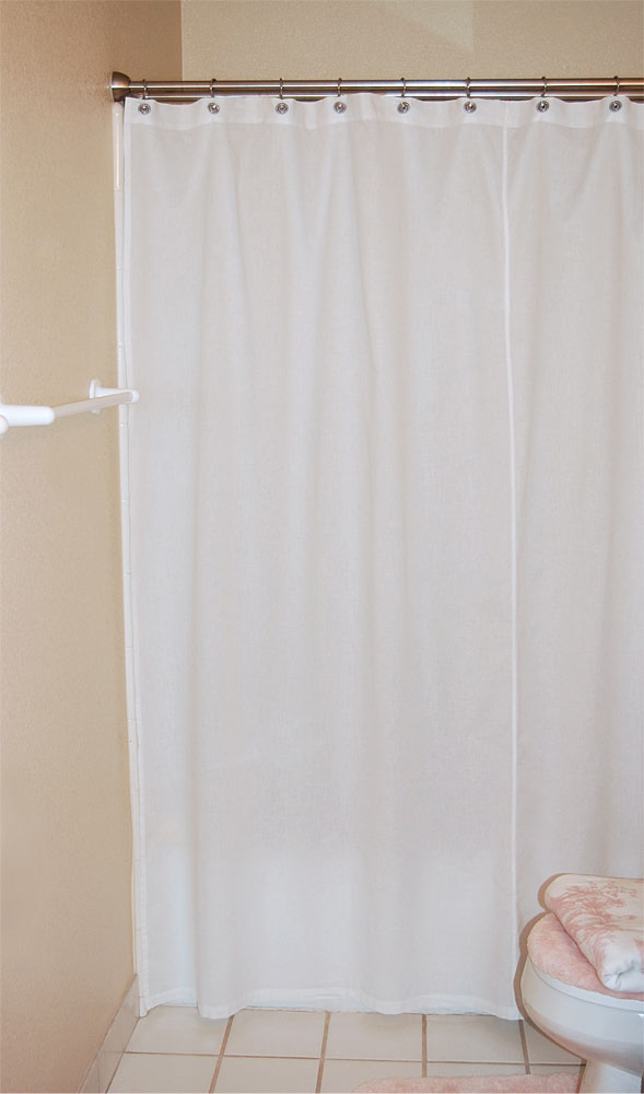 White 100% woven cotton Garuda fair trade shower curtain hanging on a shower rod in a cream bathroom.