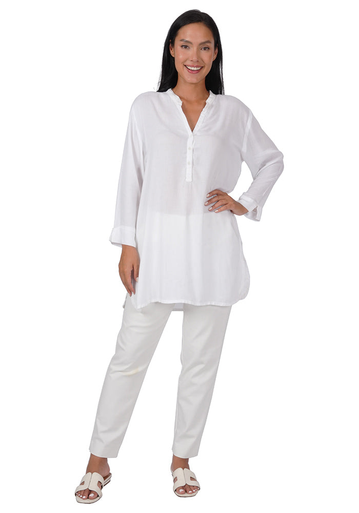 Woman wearing a white rayon tunic with 3 buttons, long sleeves, and a loose fit on a white background.