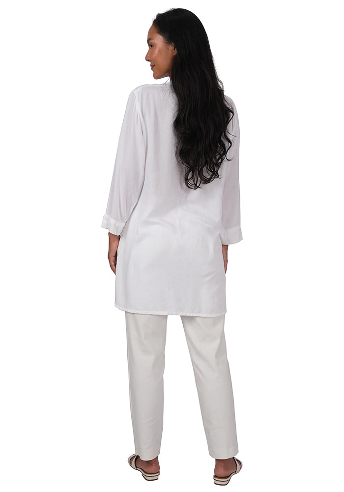 Back view oman wearing a white rayon tunic with long sleeves and a loose fit on a white background.