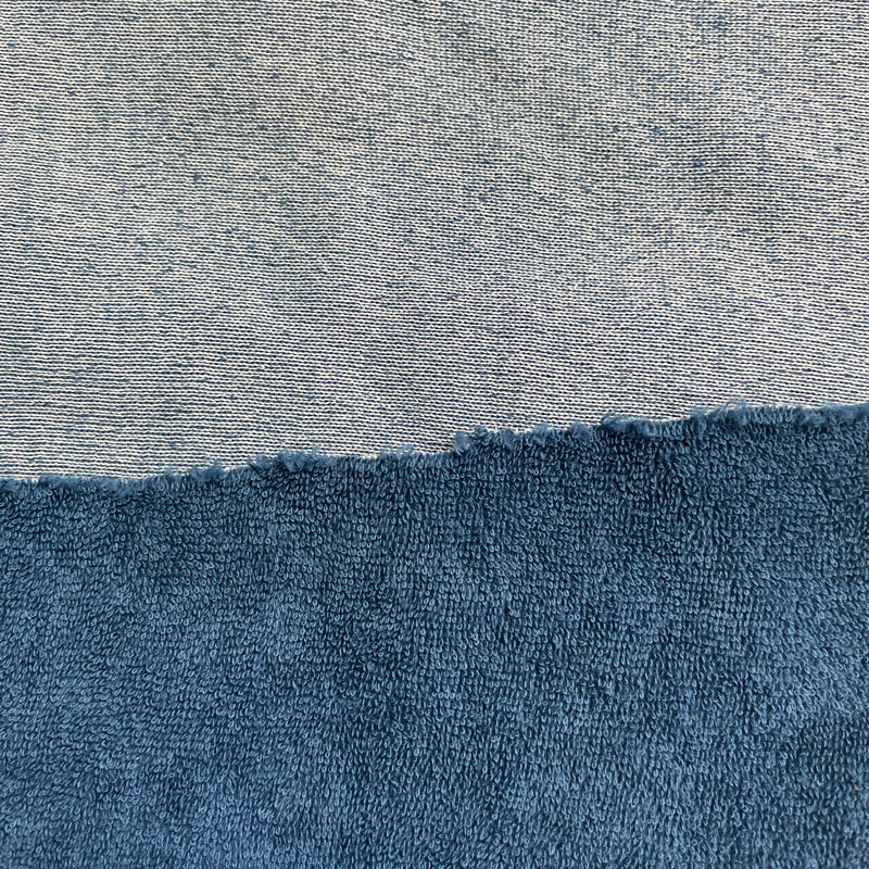 A dyed sample of terry cloth fabric with a cotton terry loop pile front that is blue, and a cotton/polyester blend backing that is white when dyed. Backing is not visible from the front view.