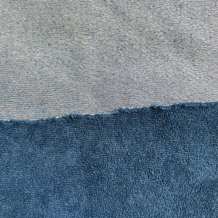 A dyed sample of terry cloth fabric with a cotton terry loop pile front that is blue, and a cotton/polyester blend backing that is white when dyed. Backing is not visible from the front view.