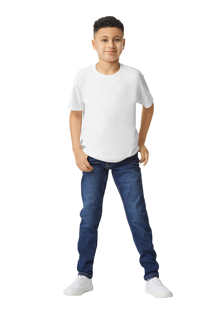 A boy wearing a Gildan 5.3 oz. heavy cotton, short-sleeved white t-shirt and blue jeans on a white background.