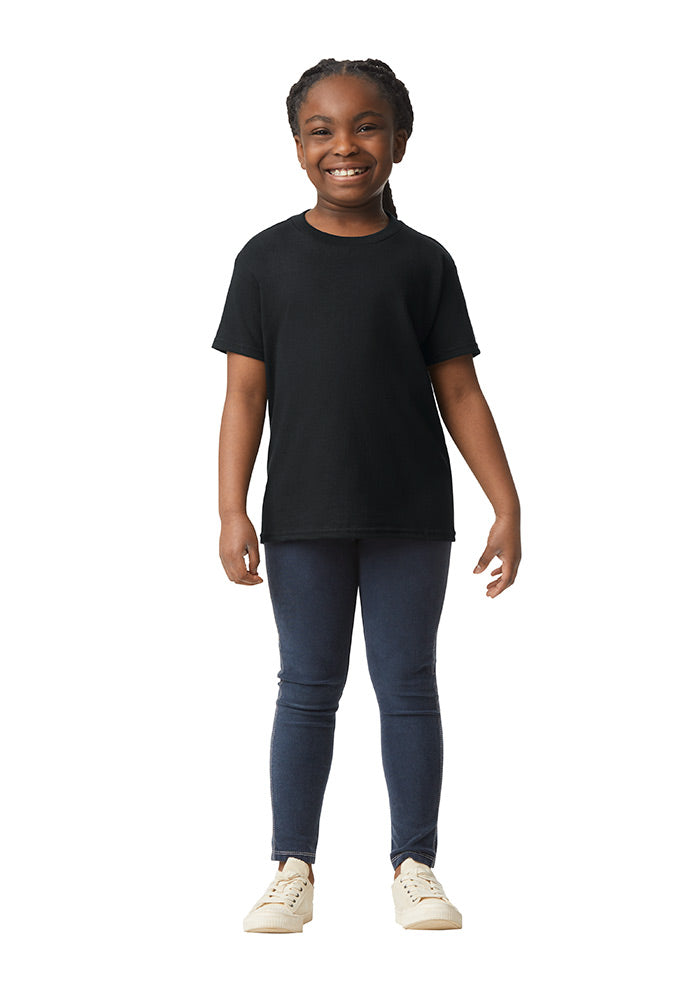 A child wearing a Gildan 5.3 oz. heavy cotton, short-sleeved black t-shirt and blue jeans on a white background.