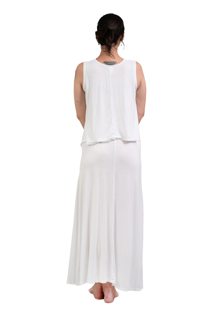 Person wearing a white sleeveless hi lo top and long white skirt on a white background