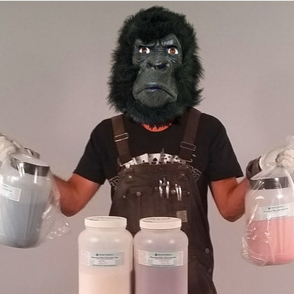 Person wearing a gorilla mask and overalls holding large jugs with different Dharma special order dyes.
