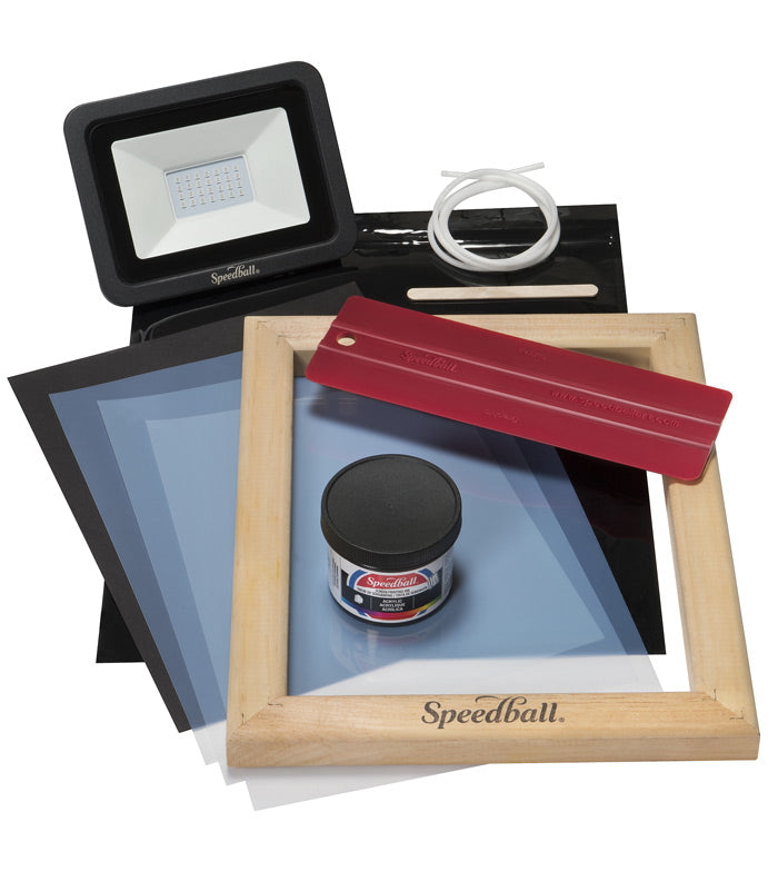 Speedball screen printing kit with a portable light, squeegee, ink, screens, stir stick, and frame on a white background.